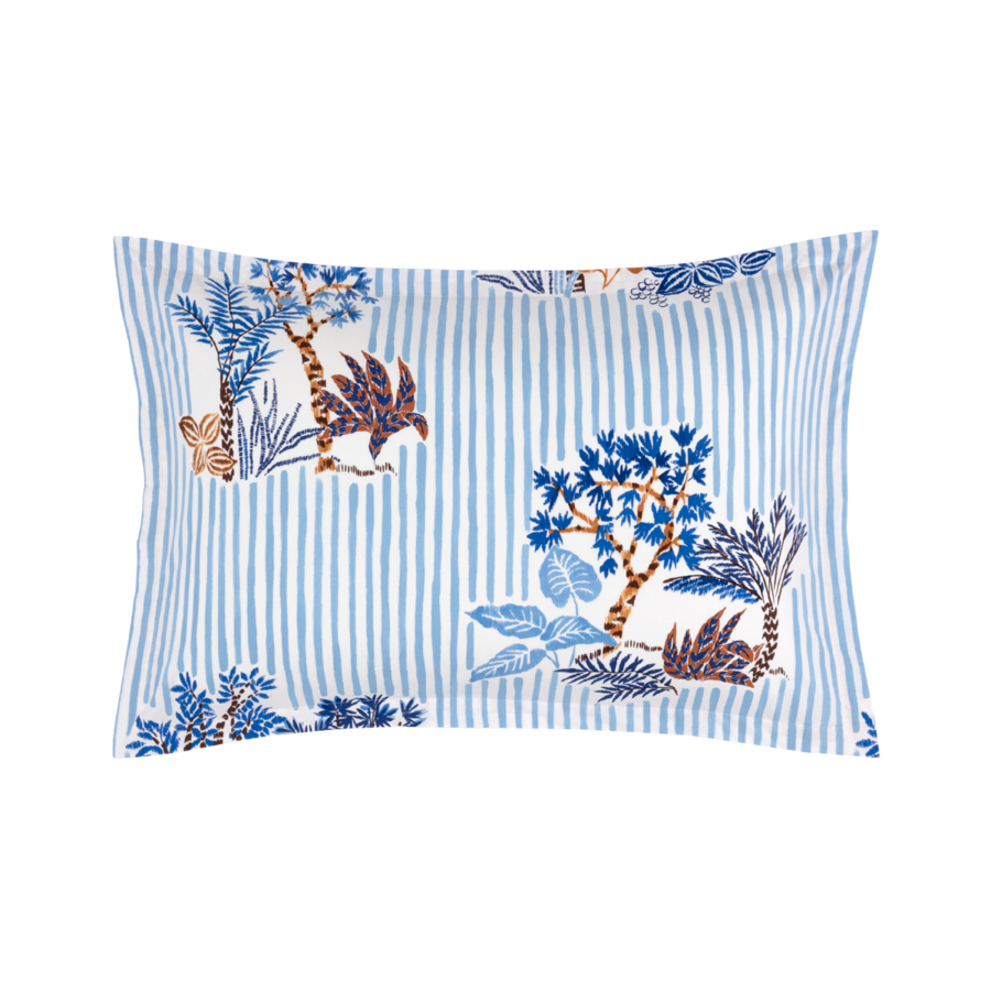Une taie d'oreiller rectangulaire à rayures bleues et blanches ornée d'un imprimé botanique d'arbres et de feuilles bleues et brunes.