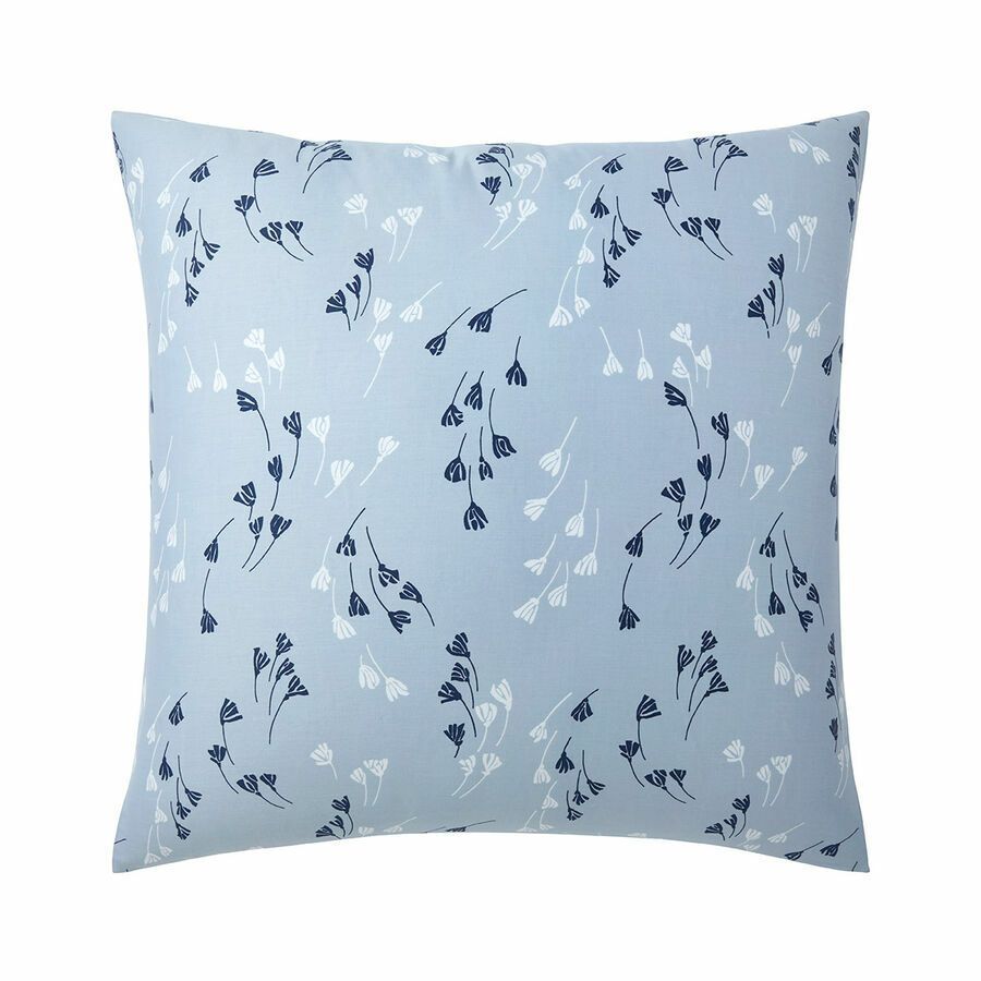 Une housse de coussin carrée bleu clair ornée d'un délicat motif répétitif de brins de fleurs sauvages bleu marine foncé et blanches.