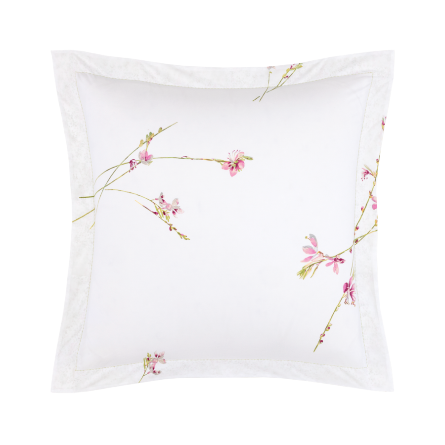 Une taie d'oreiller carrée blanche ornée de fines tiges délicates et de petites fleurs roses dispersées sur le tissu.