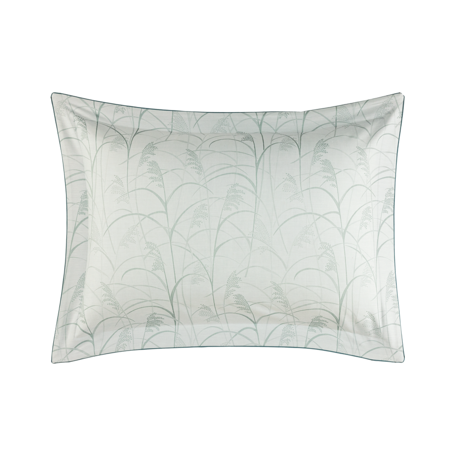 Taie d'oreiller blanche à motif de feuilles turquoise et argentées.