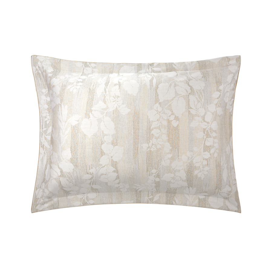 Un oreiller blanc avec un motif floral dessus sur un fond blanc.