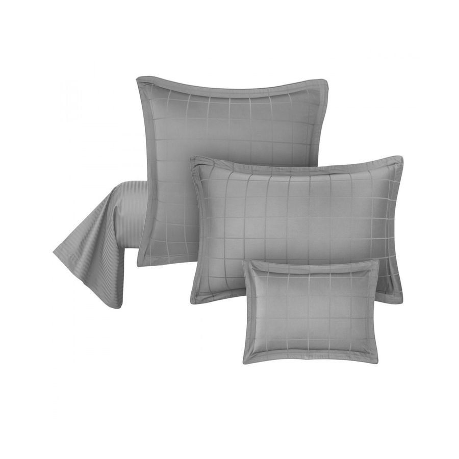 Trois oreillers gris sont empilés les uns sur les autres sur un fond blanc.