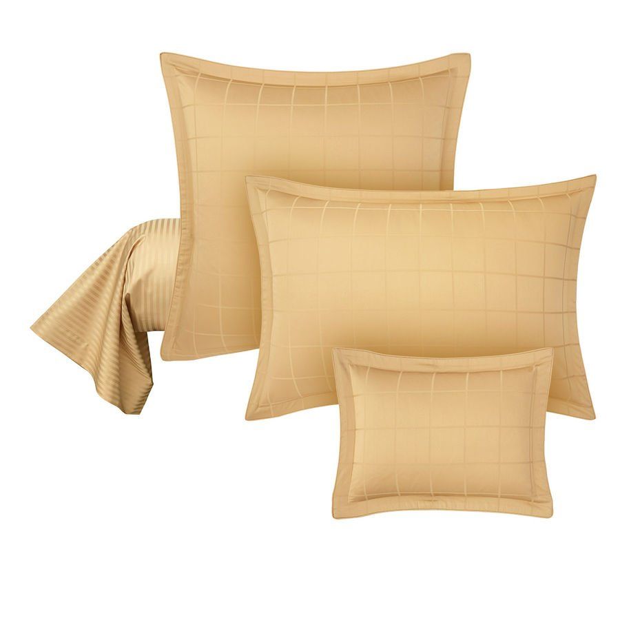 Un lit avec trois oreillers et une couverture dessus