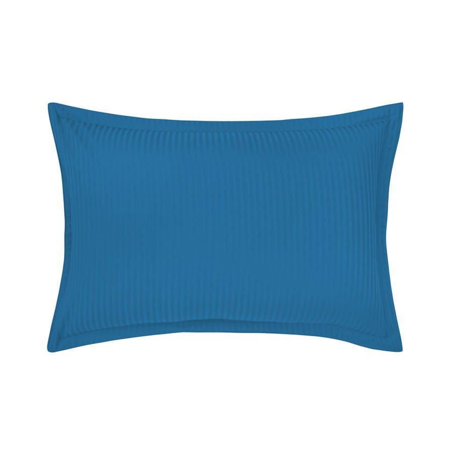 Un oreiller bleu avec une bordure blanche sur fond blanc