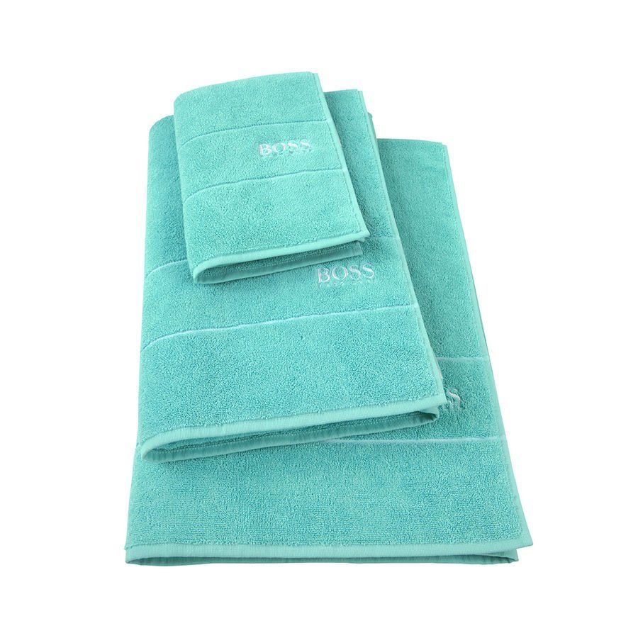 Trois serviettes turquoise sont empilées les unes sur les autres