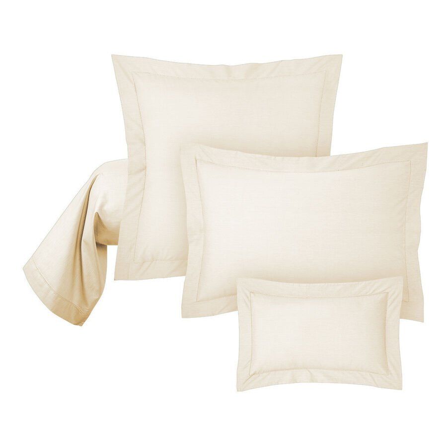 Quatre oreillers blancs sont empilés les uns sur les autres sur un fond blanc