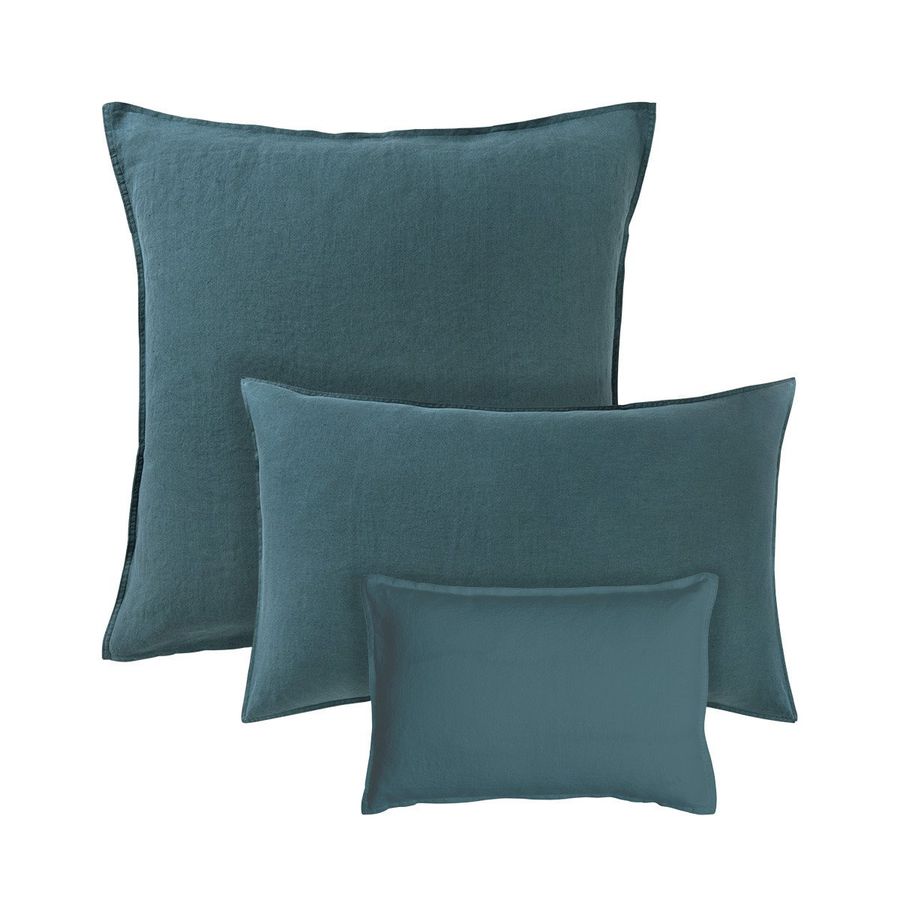 Trois oreillers bleus sont empilés les uns sur les autres sur un fond blanc