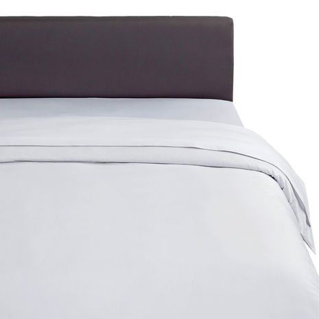 Un lit avec une couette blanche et une tête de lit grise