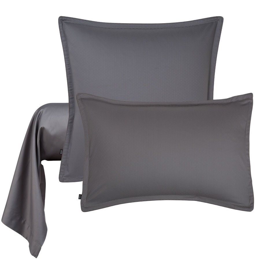 Deux oreillers gris sont posés l'un à côté de l'autre sur un lit.