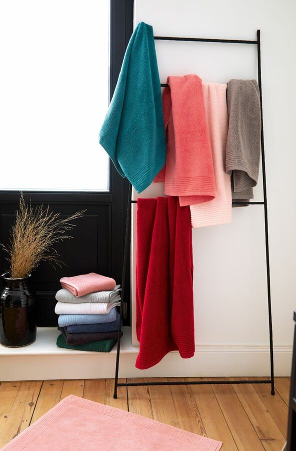 Un tas de serviettes accrochées à un support dans une salle de bain