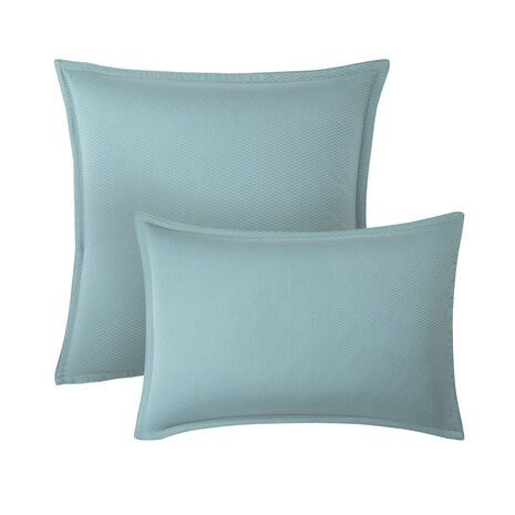 Deux coussins bleus sont posés côte à côte sur un fond blanc.