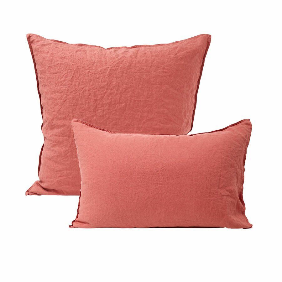 Deux oreillers roses sont assis l'un à côté de l'autre sur un fond blanc