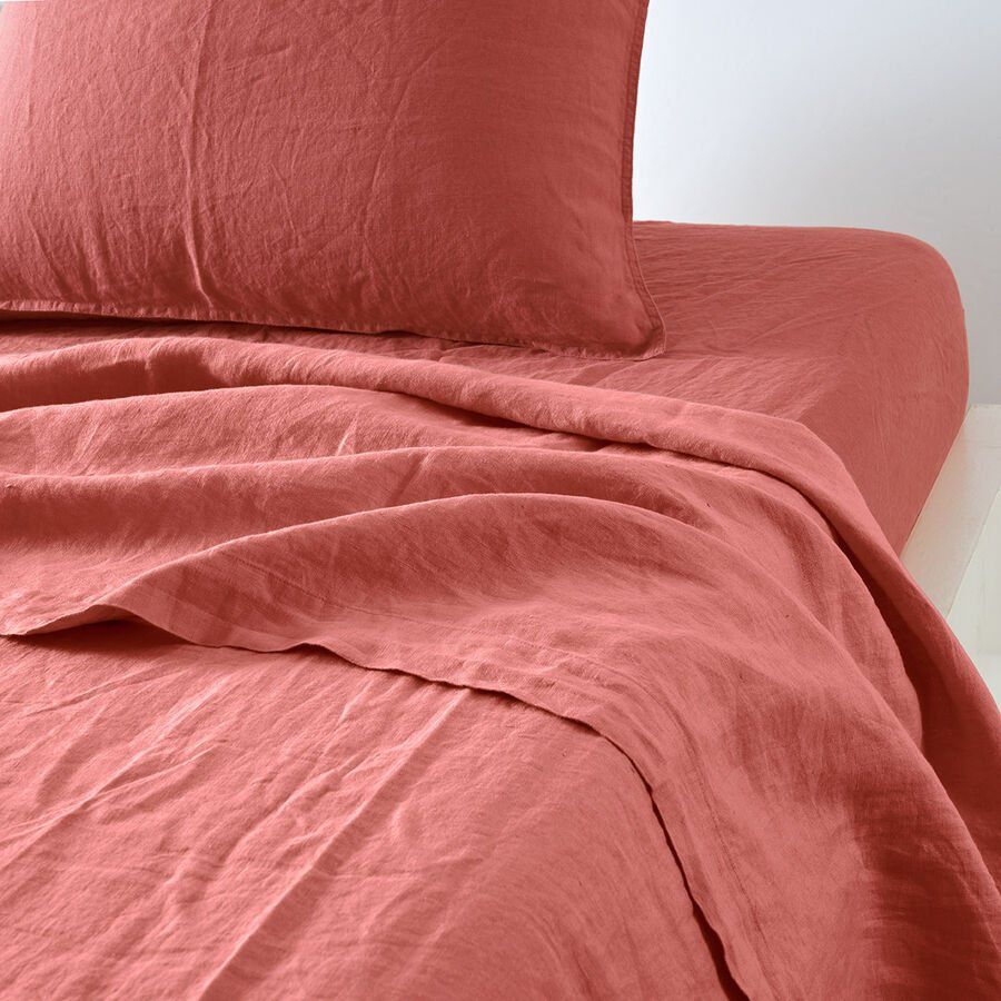 Un lit avec une couette rouge et des oreillers dessus