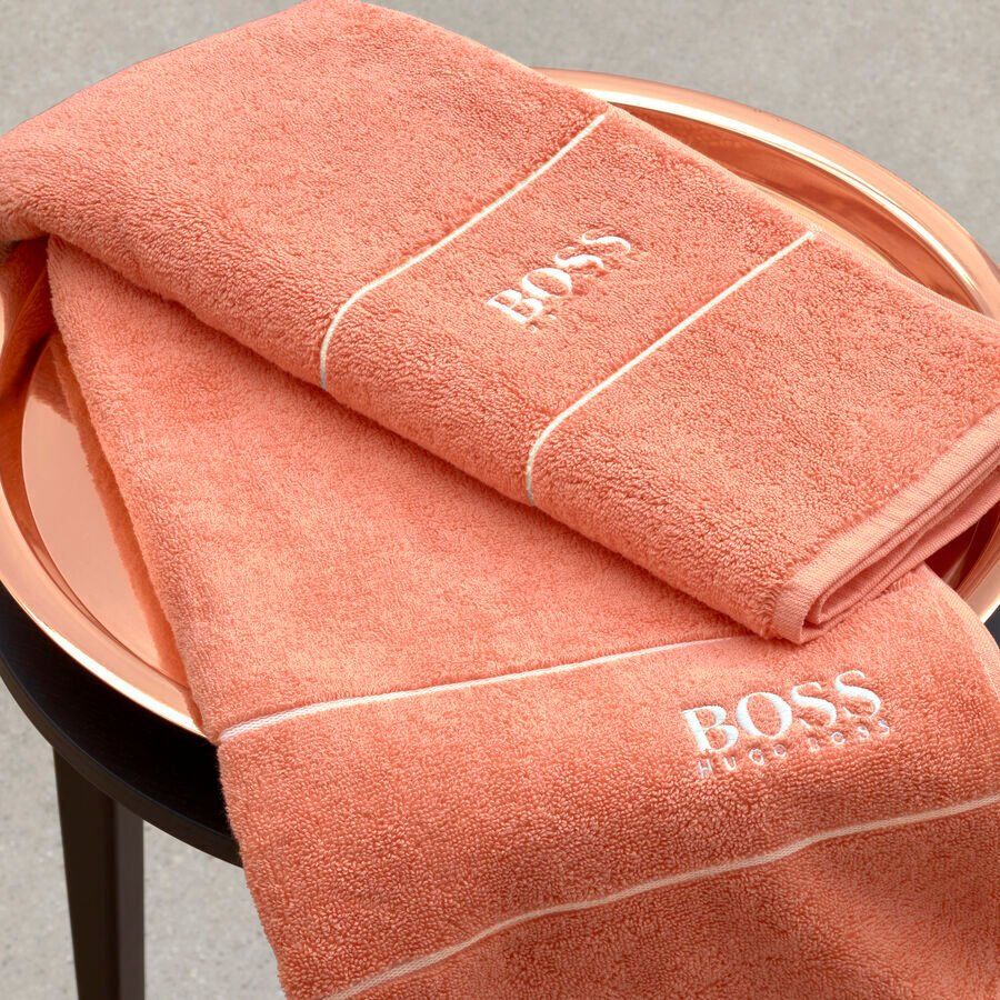 Deux serviettes roses avec le mot boss brodé dessus