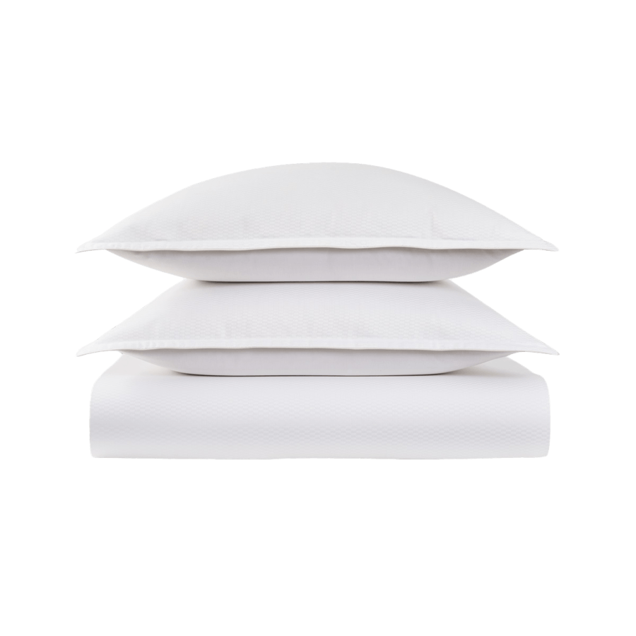 Trois oreillers blancs sont empilés les uns sur les autres sur un fond blanc.