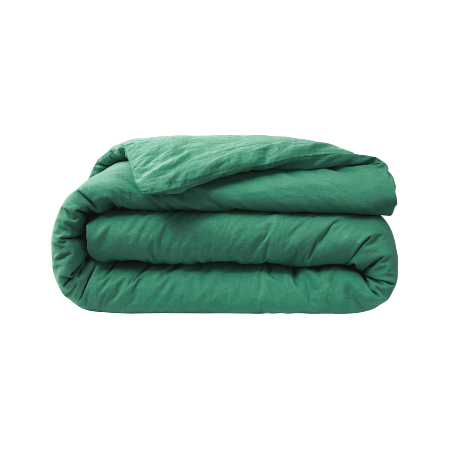 Une couette verte est enroulée sur un fond blanc