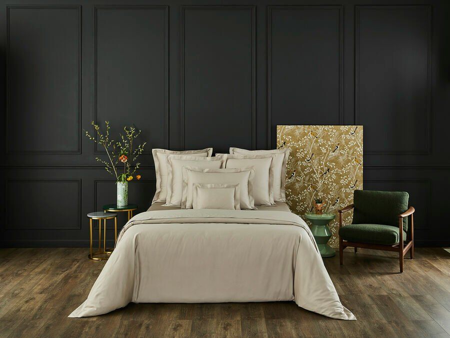 Il y a un lit avec une couette blanche et des oreillers dans la chambre.