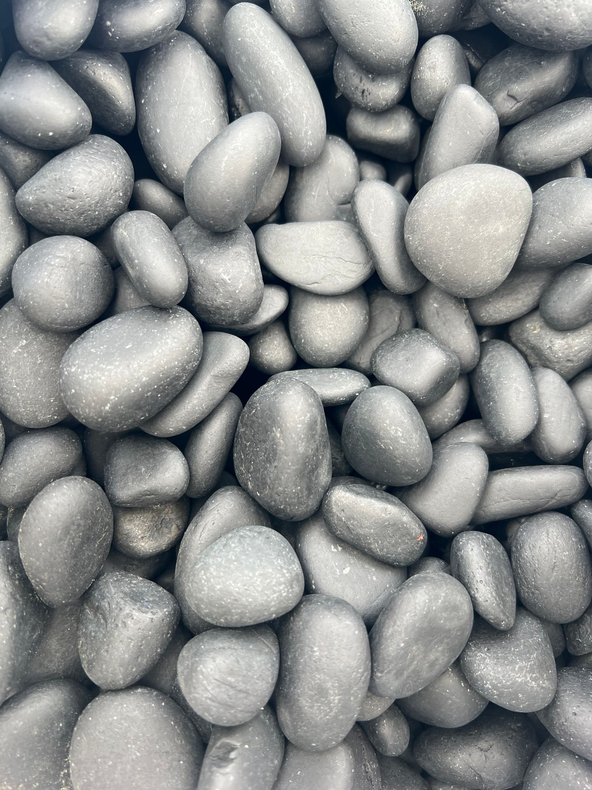 A pile of black rocks is sitting on top of each other.