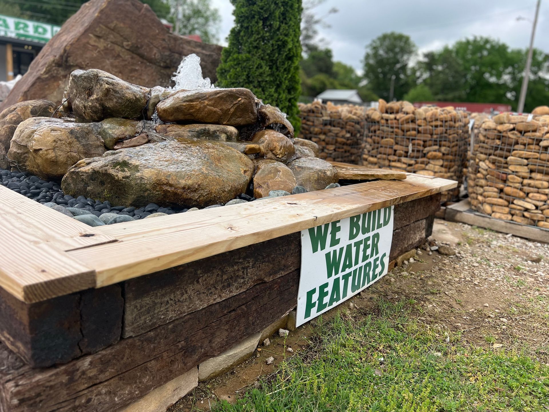 A water fountain with a sign that says `` we build water features ''.