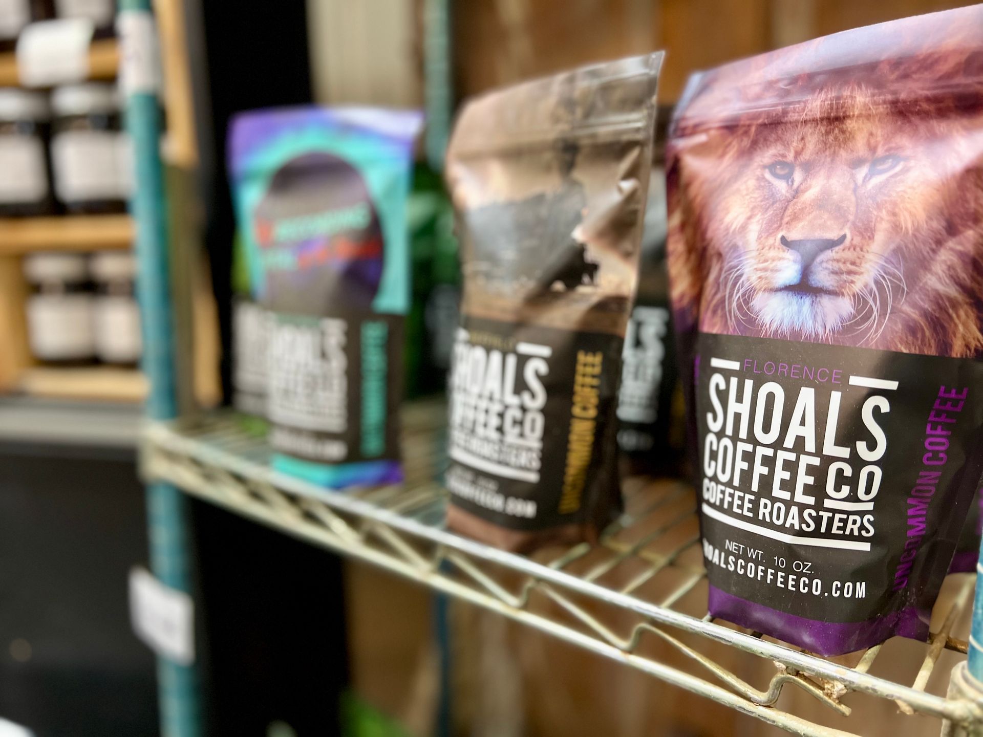 A shelf filled with bags of shoals coffee co. coffee.