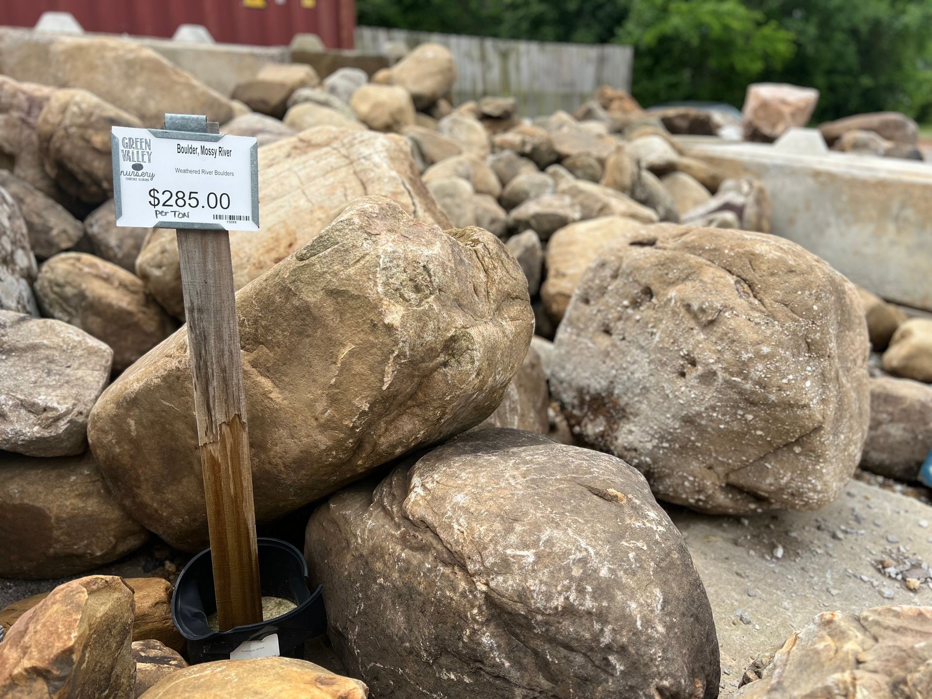 A pile of rocks with a sign on a wooden post.