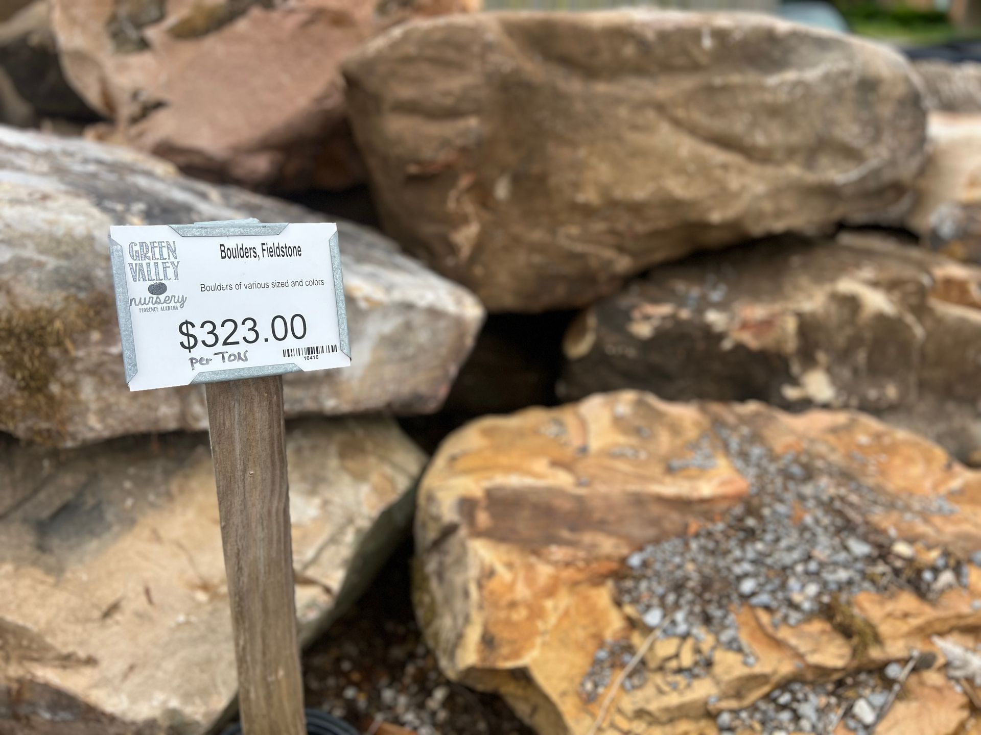 A pile of rocks with a sign that says $ 323.00 on it.