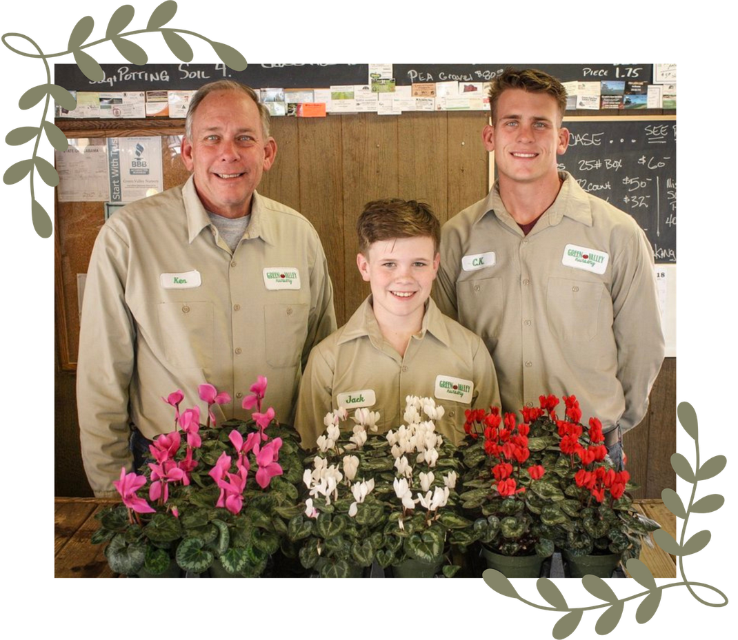 Three men are posing for a picture with flowers in the background