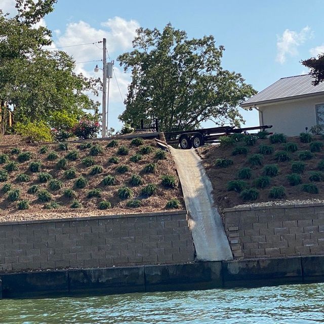 A trailer is going down a hill into the water