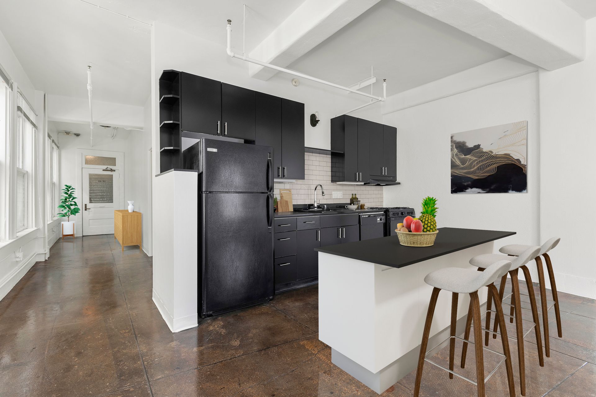 Modern kitchen with black cabinets, white island, and bar stools in a bright apartment