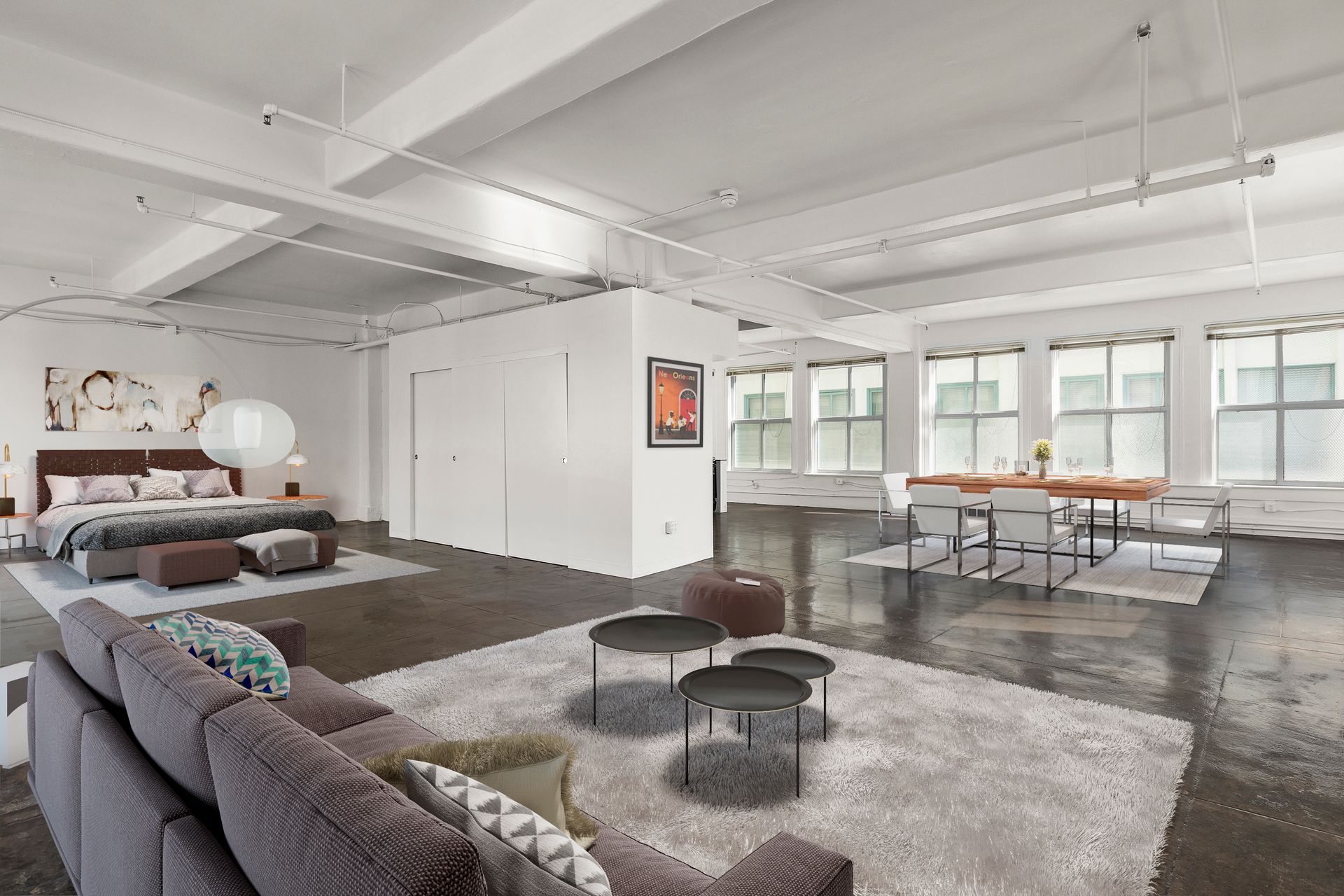 Modern loft living room with sofa, rug, beds, and large windows in bright open space