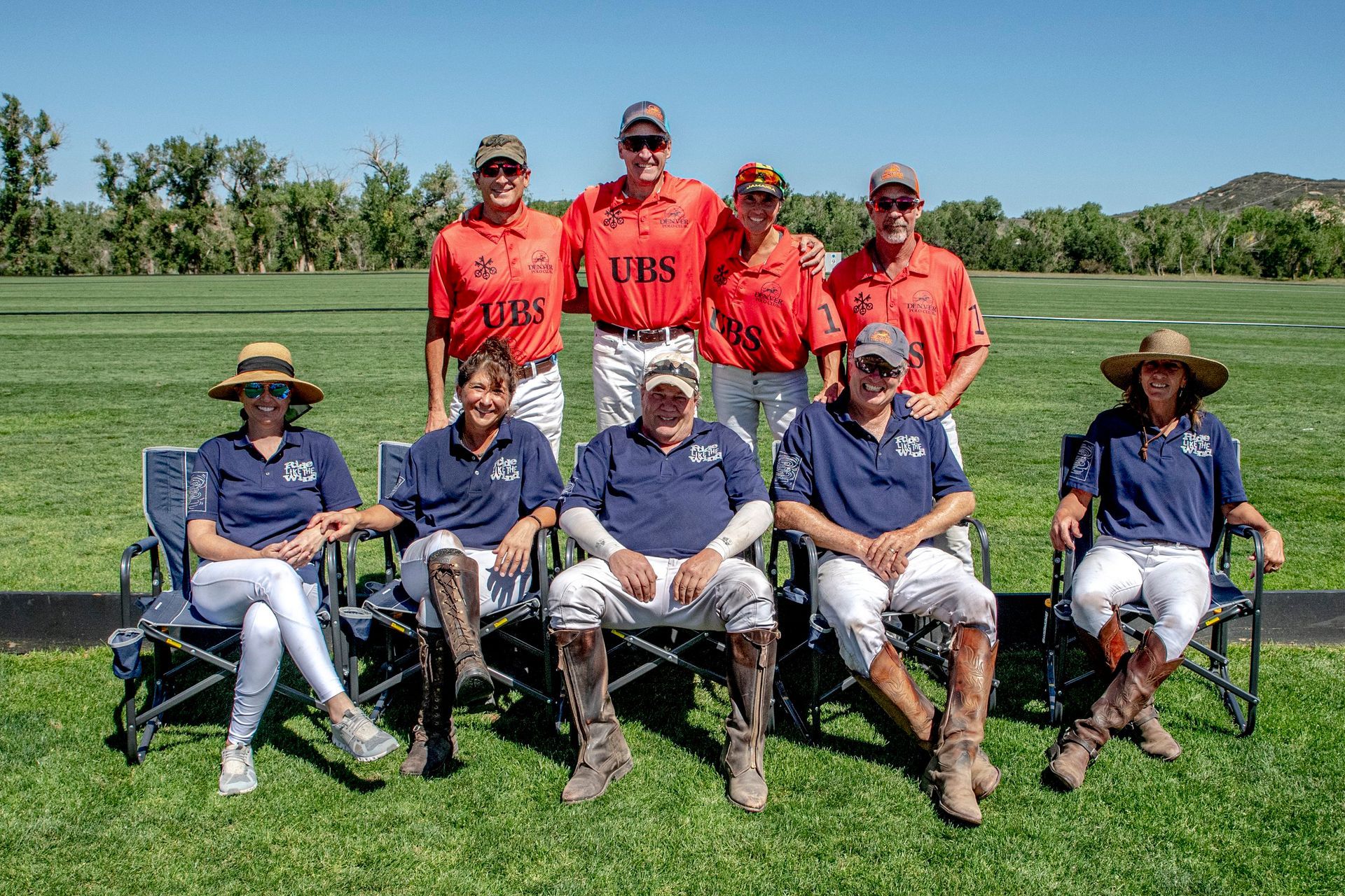 A group of people are sitting in chairs on a field.