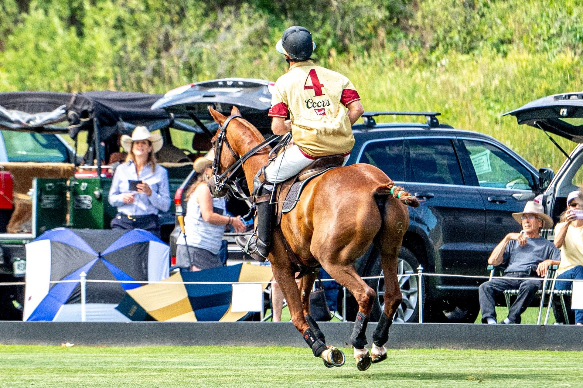 A man is riding a horse on a polo field.