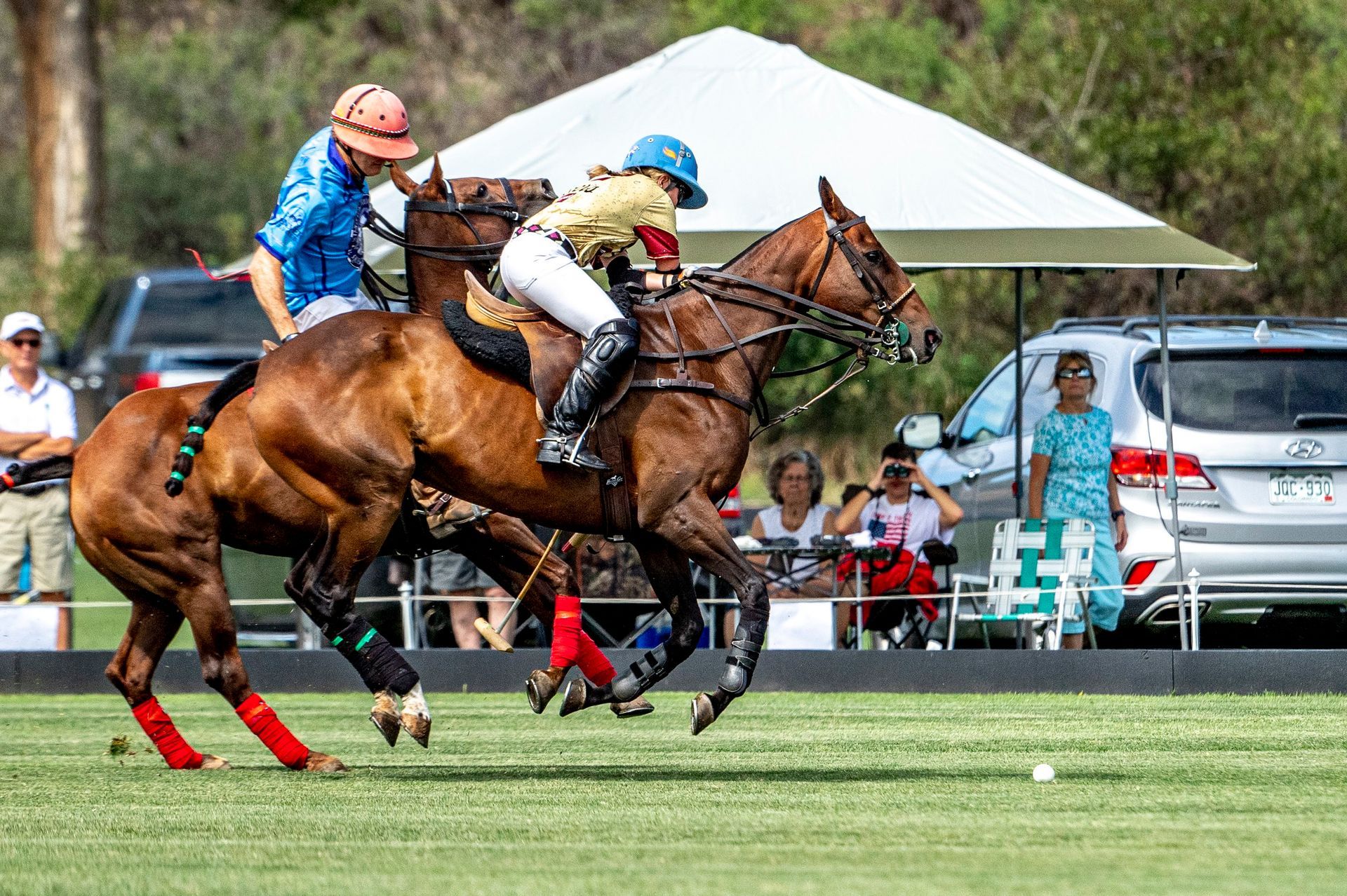 A group of people are riding horses on a polo field.