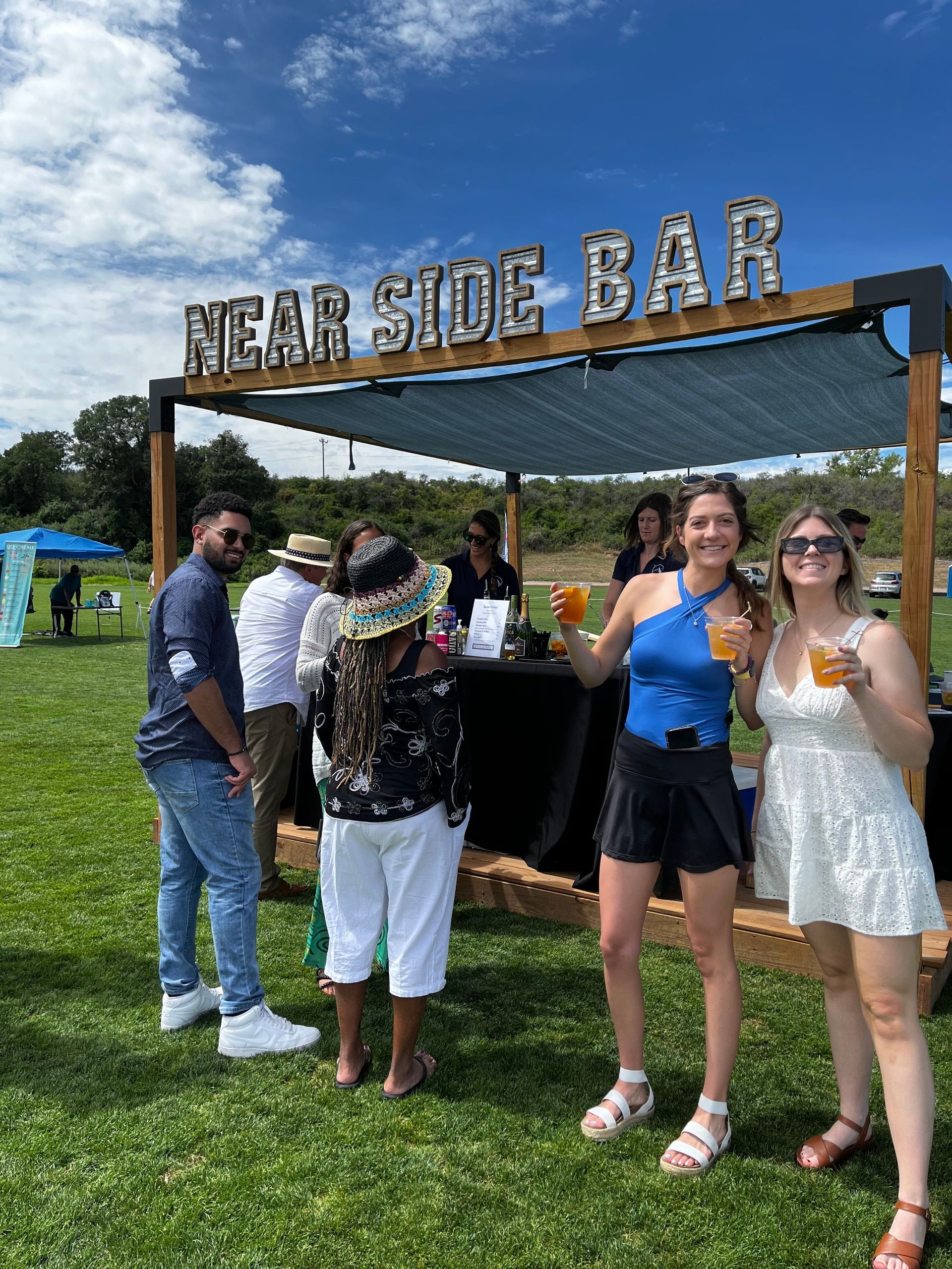 A group of people are standing in front of a near side bar.