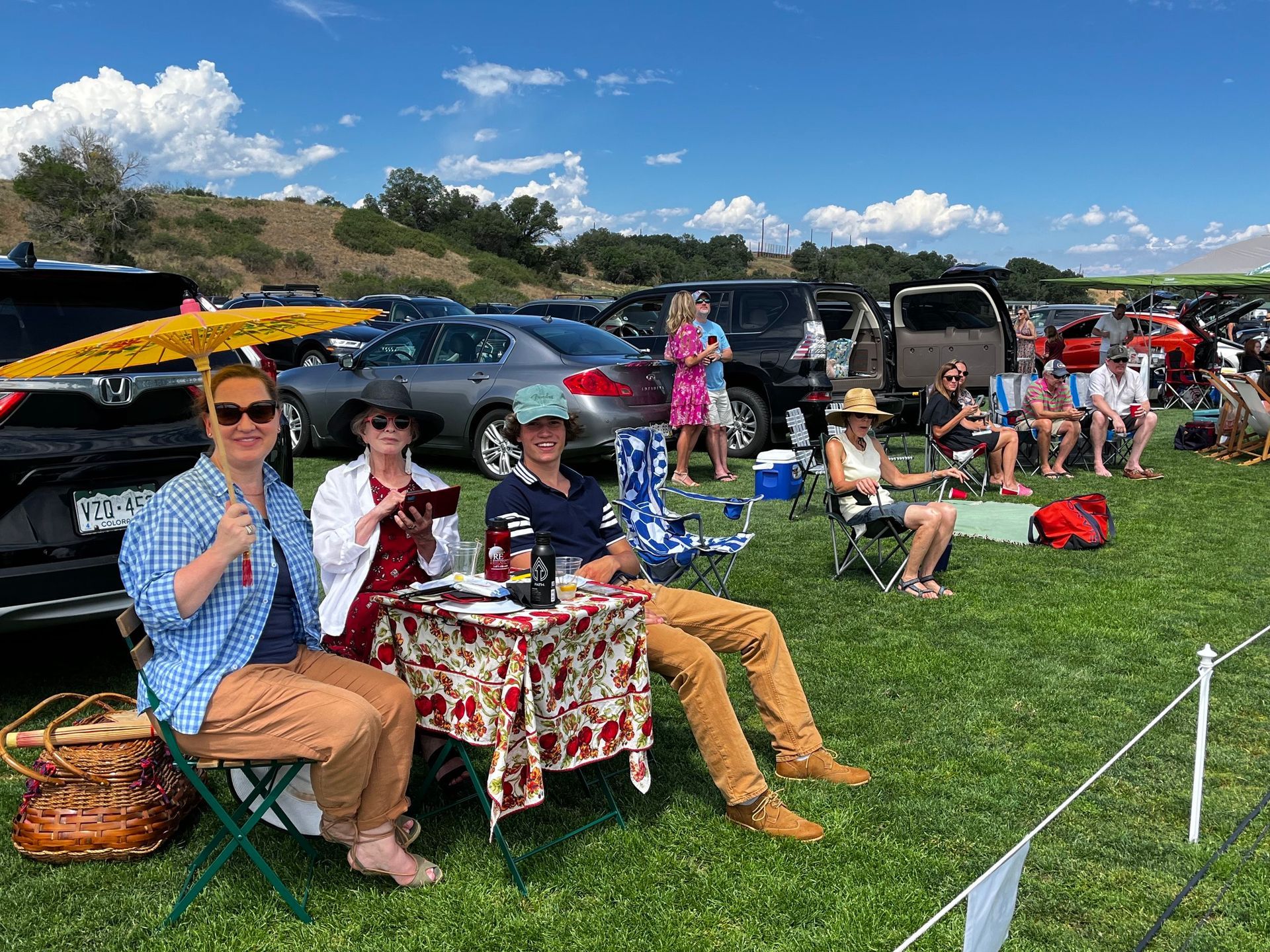 A group of people are sitting in chairs in a grassy field.