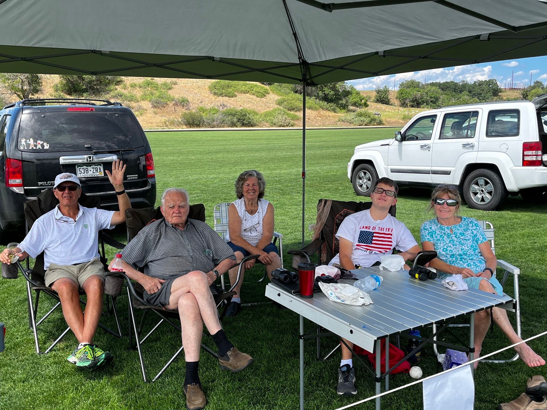 A group of people are sitting at a table under a tent.