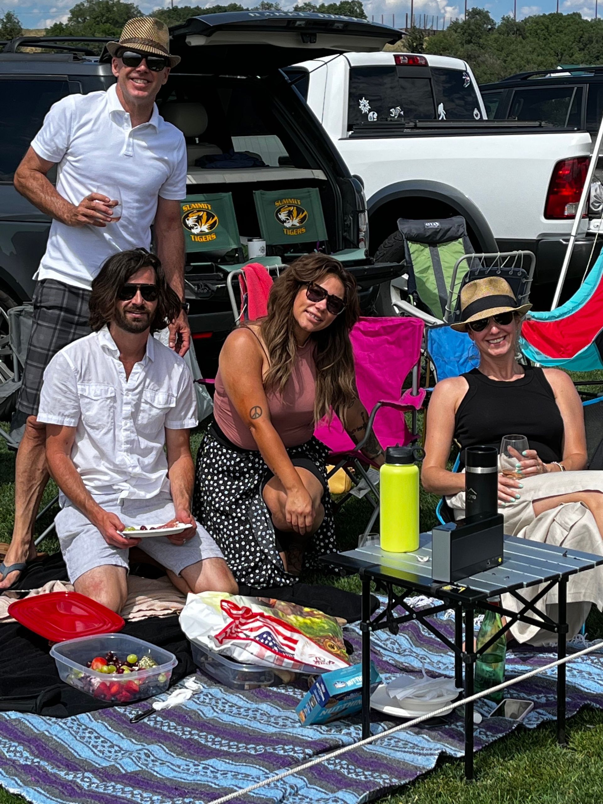 A group of people are having a picnic in the back of a truck.