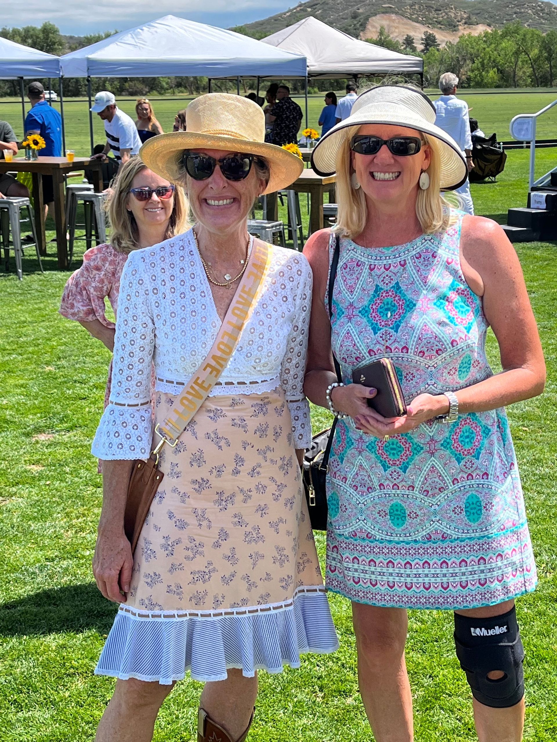 Two women are posing for a picture in a field.