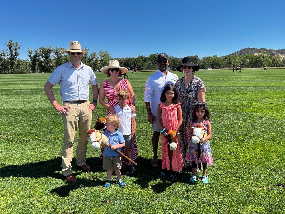 A group of people are posing for a picture in a field.
