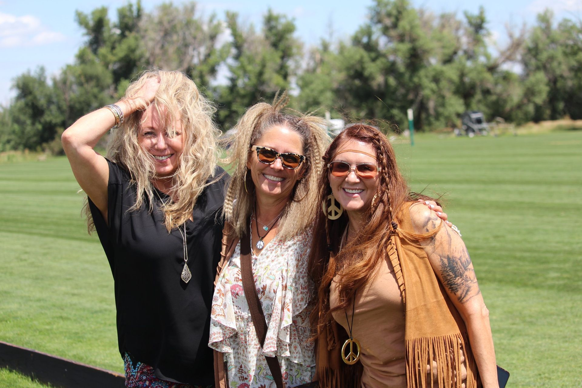 Three women are posing for a picture on a golf course.