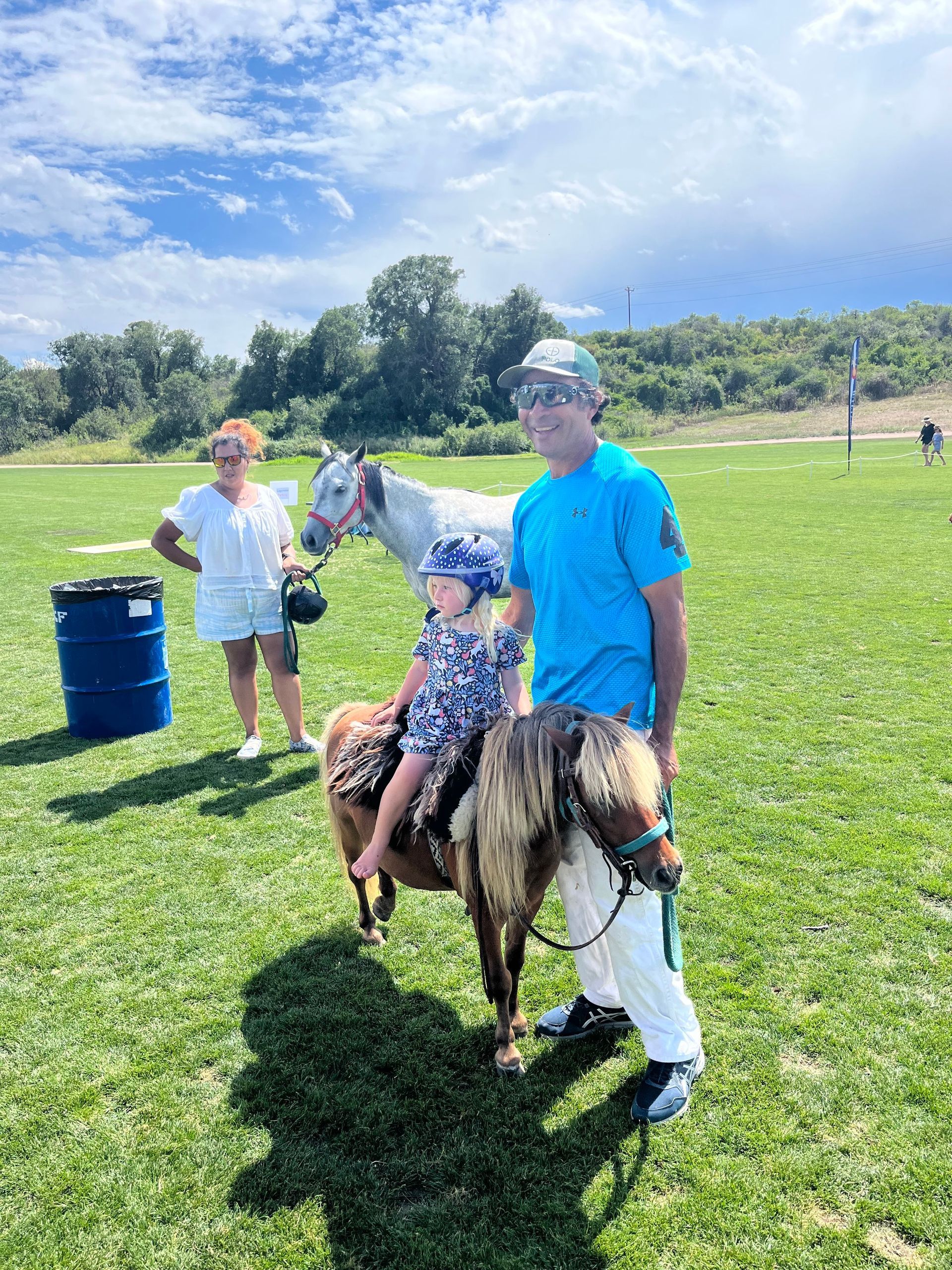 A man and a child are riding a pony in a field.