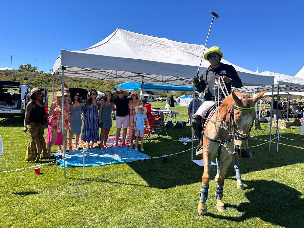 A man is riding a horse in front of a group of people.