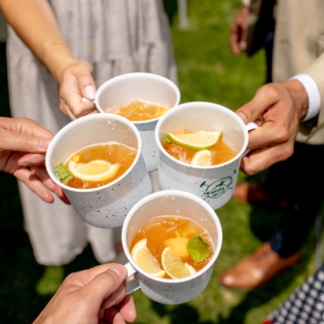 A group of people holding cups of tea with lemon slices
