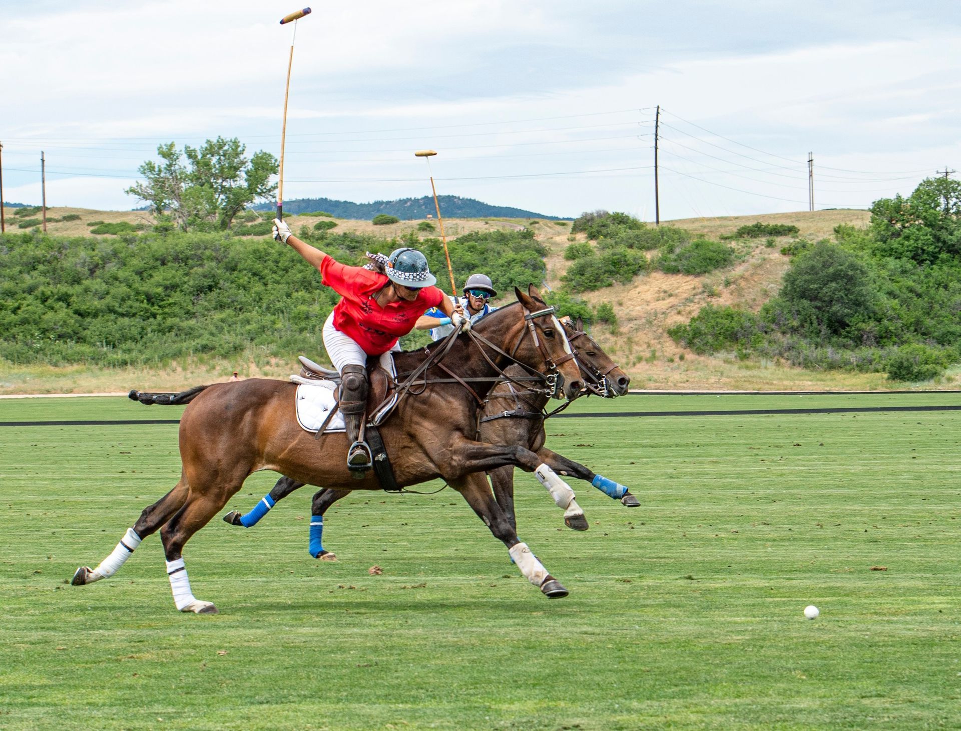 A man is riding a horse while playing polo on a field.