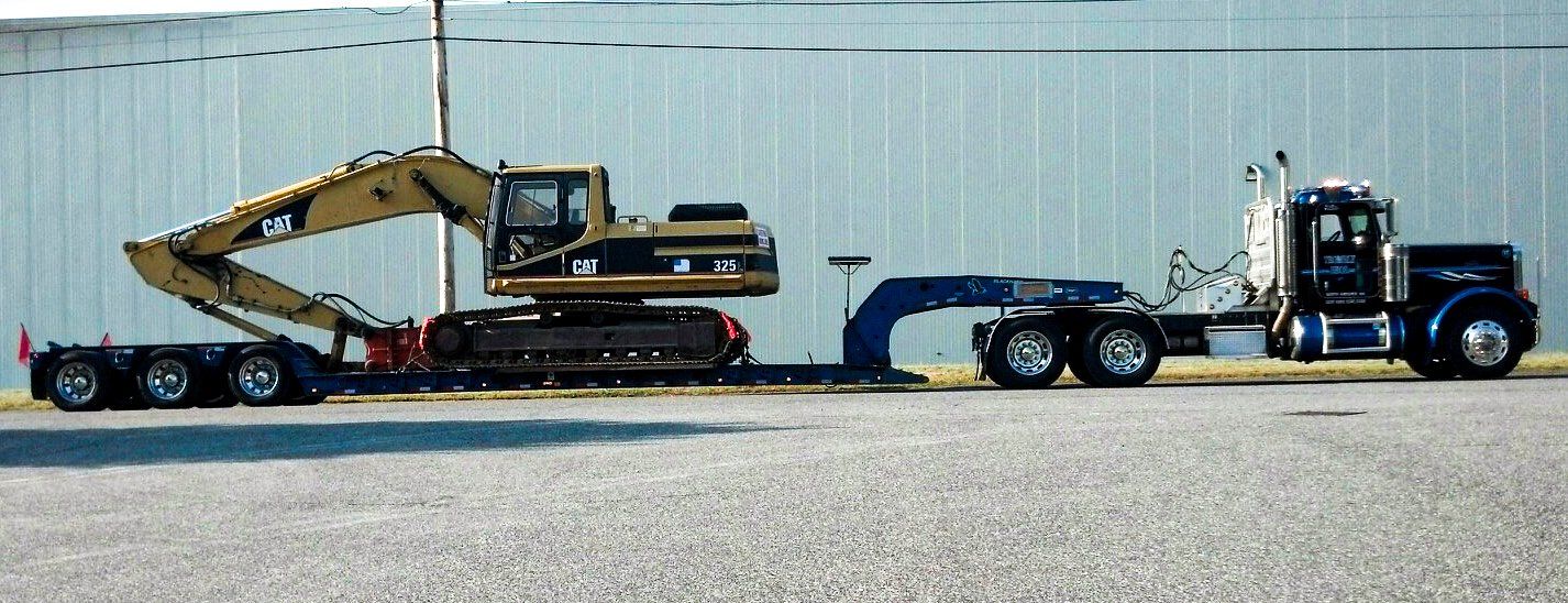 Trombly truck towing large construction equipment