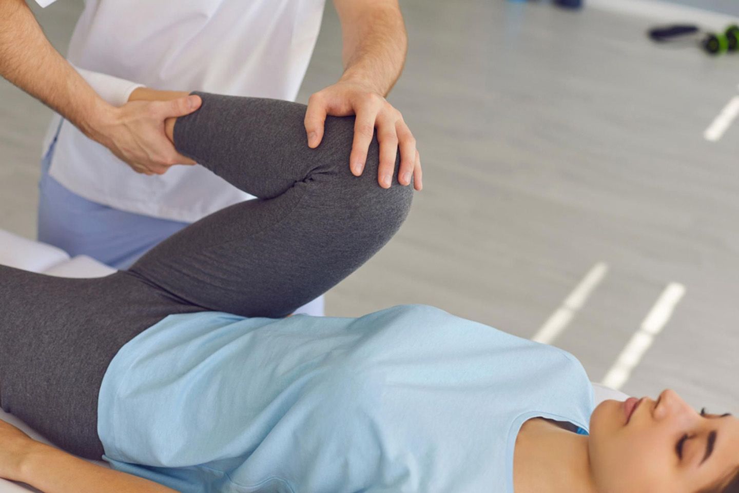 Physical Therapist Stretching A Patient’s Leg During A Therapy Session