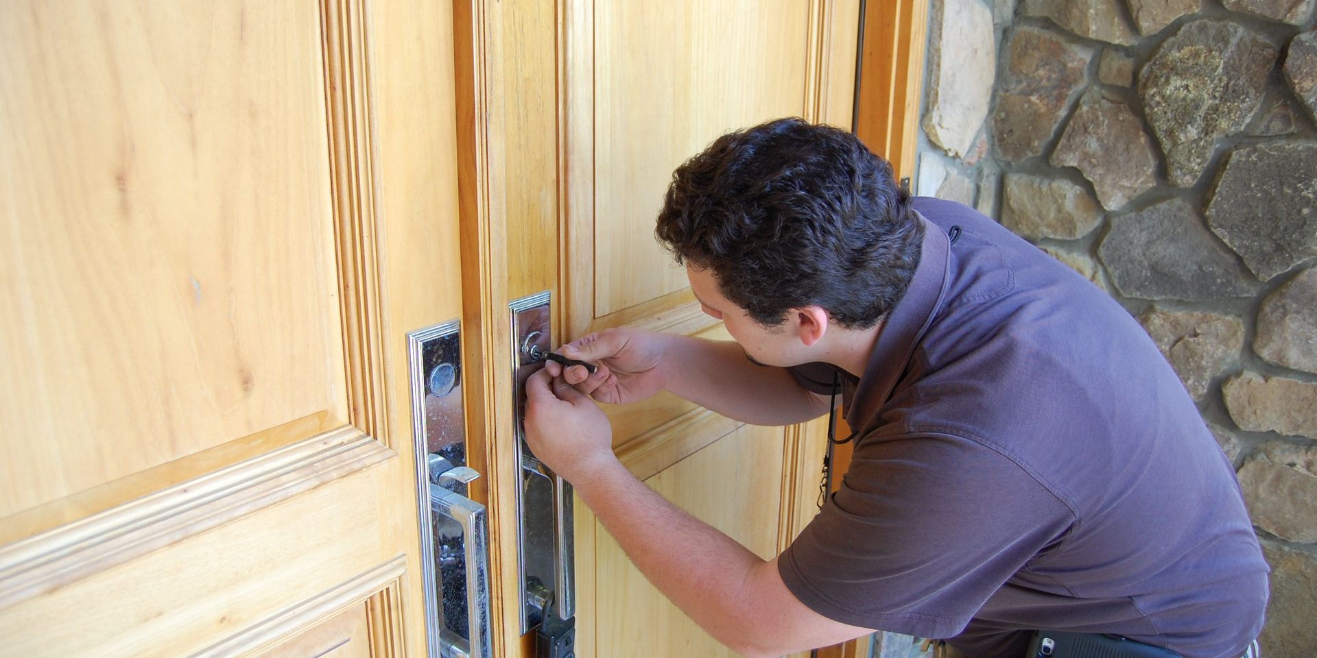 A man is fixing a door with a screwdriver.