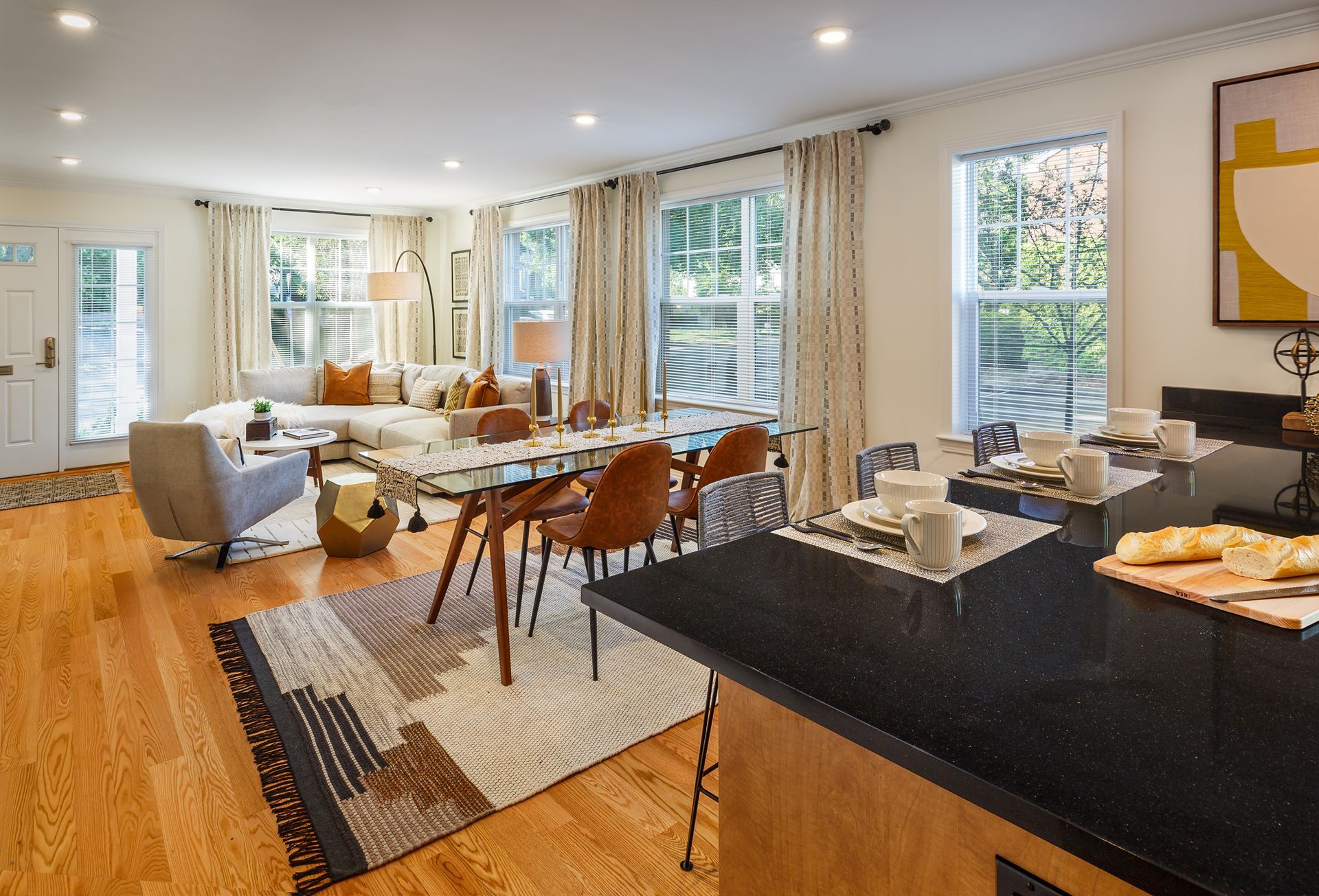 Open-concept living space with dining area and kitchen. Hardwood floors, natural light, and modern furnishings.