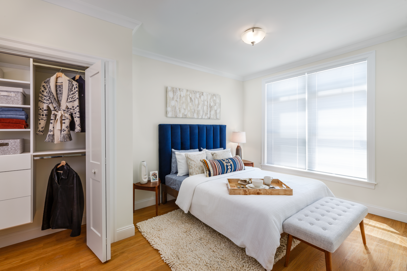 A bedroom with a large bed and a walk in closet.