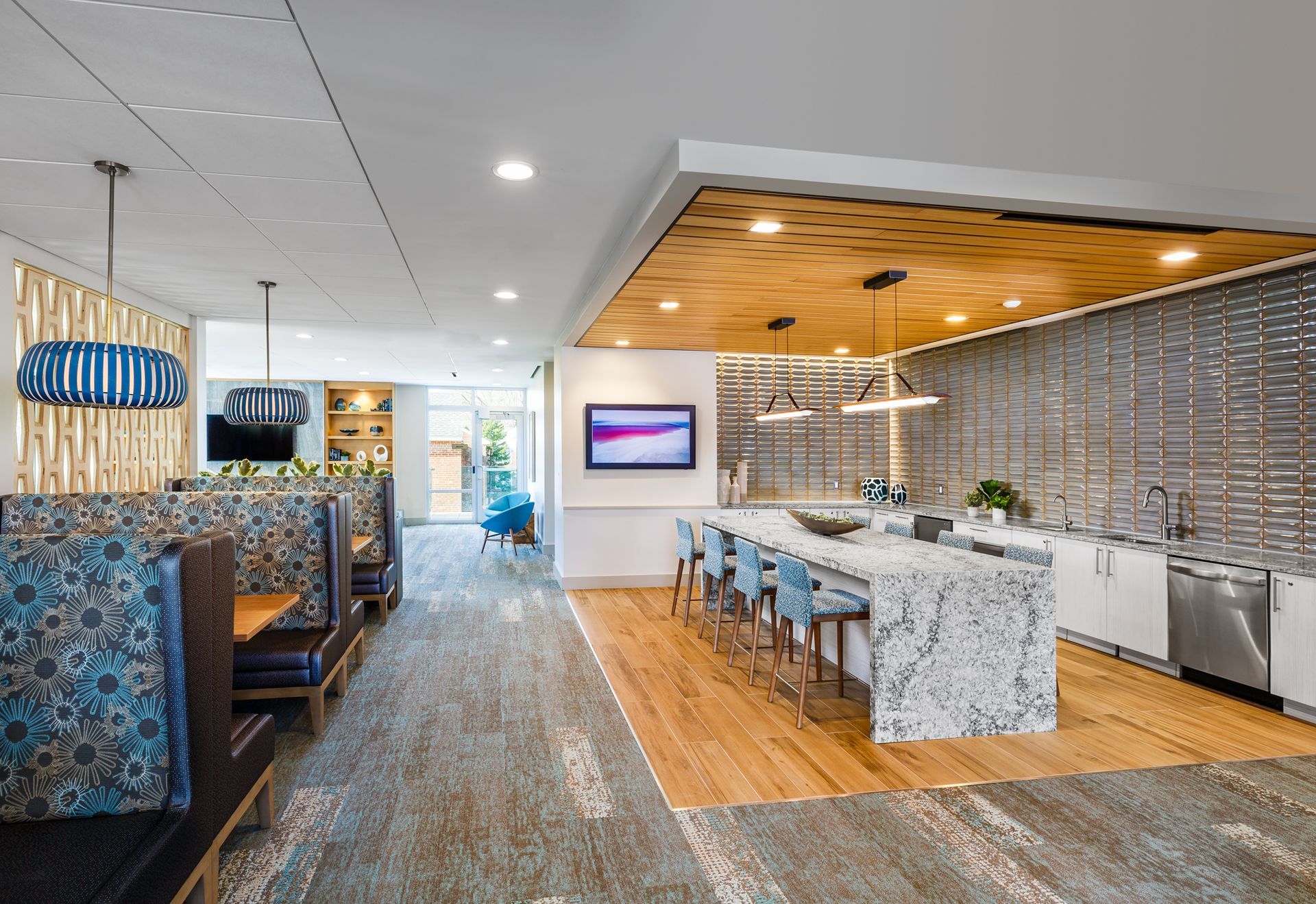 A kitchen with a large island and a television on the wall.